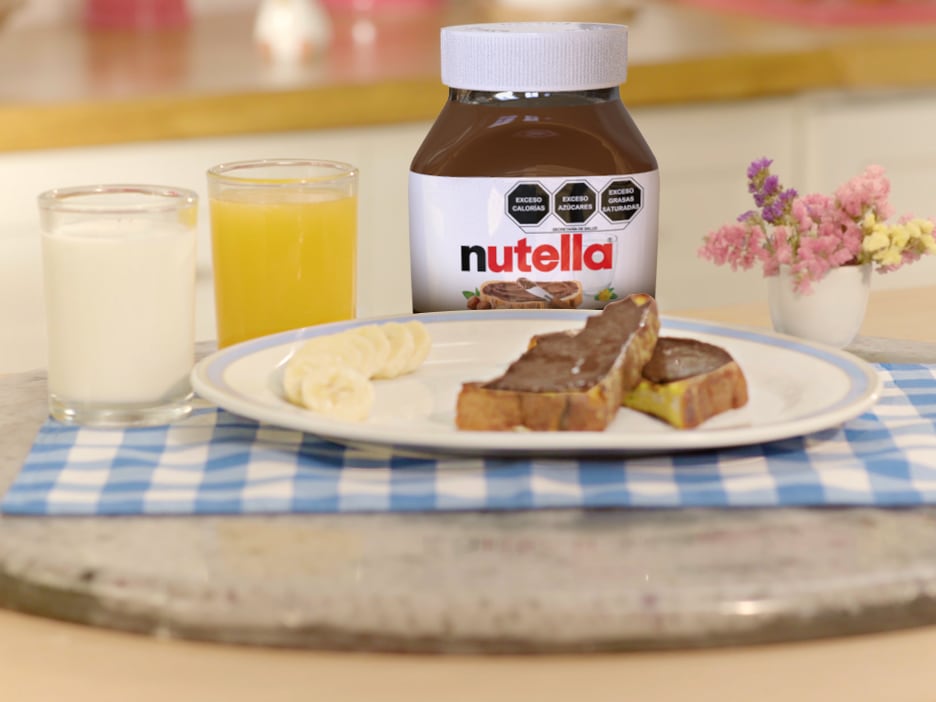 Pan francés dorado con Nutella y frutas, servido en plato.