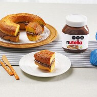 Ciambella esponjosa con glaseado de Nutella, decorada con azúcar glas.