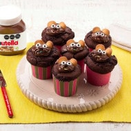 Cupcake con mousse de Nutella y crema, decorado con cacao espolvoreado.