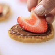 Paso de receta: galletas en forma de corazón rellenas y decoradas.