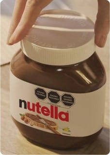 Rebanada de pan untada con Nutella, detalle apetitoso y cercano.