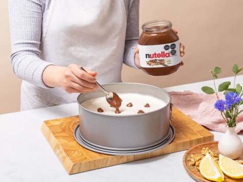 Usando una cucharita, el repostero inserta cucharadas de Nutella® en el relleno, asegurándose de que quede algo de espacio entre las cucharadas.