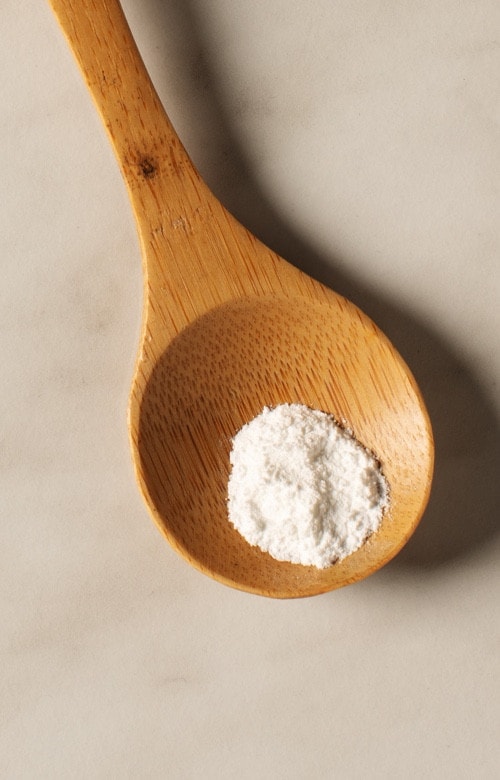 Cucharilla con extracto de vainilla (vanillina), ingrediente aromático, primer plano.