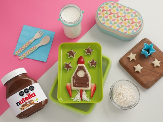 Postre con forma de cohete decorado con Nutella y confites coloridos.