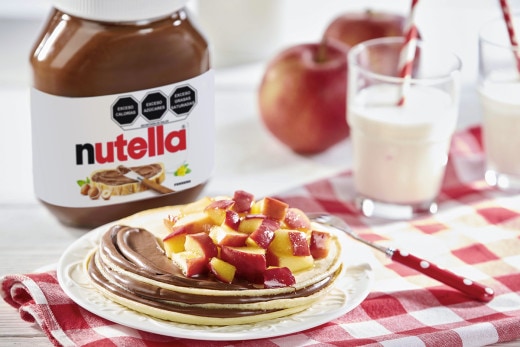 Panqueques con Nutella y manzana caramelizada, apilados y decorados.