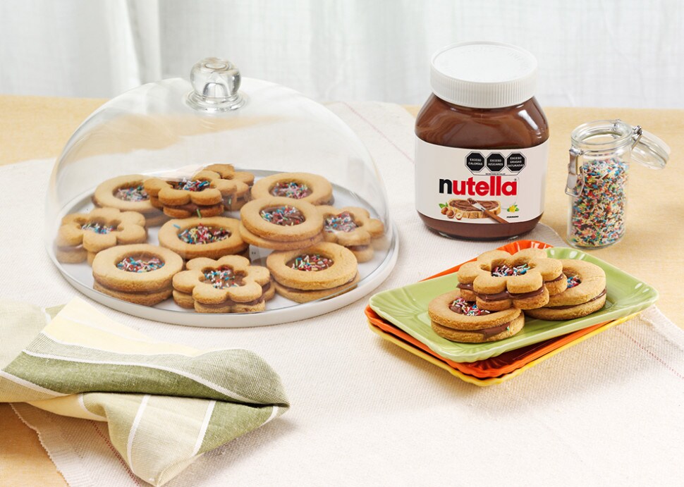 Galletas caseras rellenas de Nutella, apiladas sobre plato rústico.