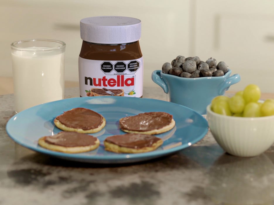 Blinis pequeños con Nutella y frutas, presentados en bandeja.
