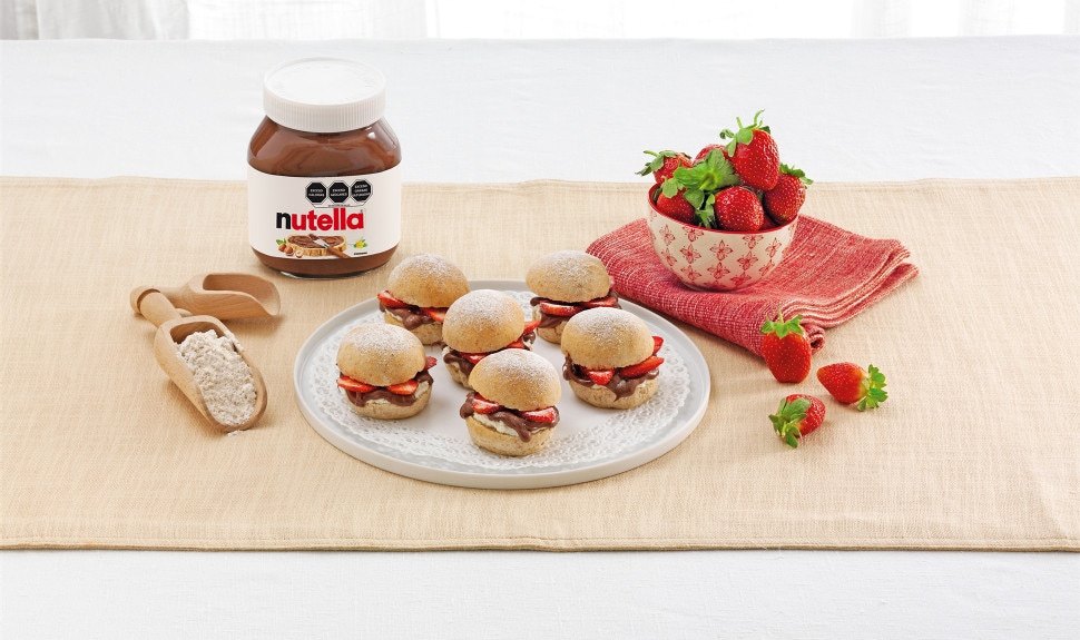 Panini tostado con Nutella y fresas, servido junto a café.