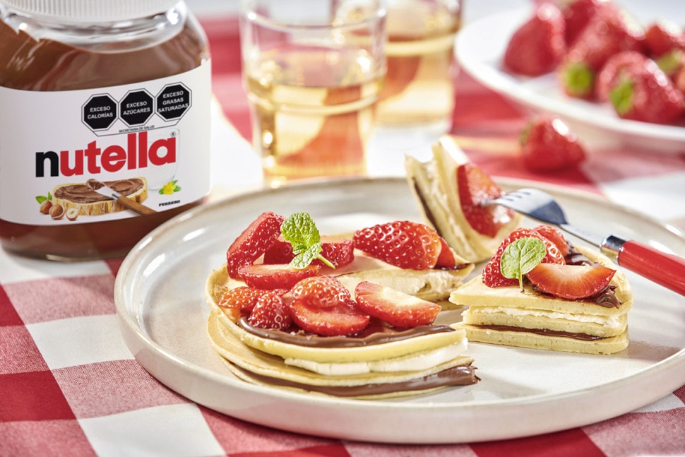 Panqueques con Nutella, mascarpone y fresas, presentación delicada y apetitosa.