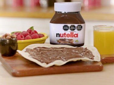 Tarta alemana con cobertura de Nutella y frutas, presentada para compartir.