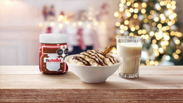 Arroz con leche cremoso espolvoreado con canela, servido en vaso..