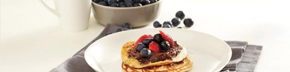 Talerz z maślanymi pancakes z borówkami, truskawkami i kremem Nutella®
