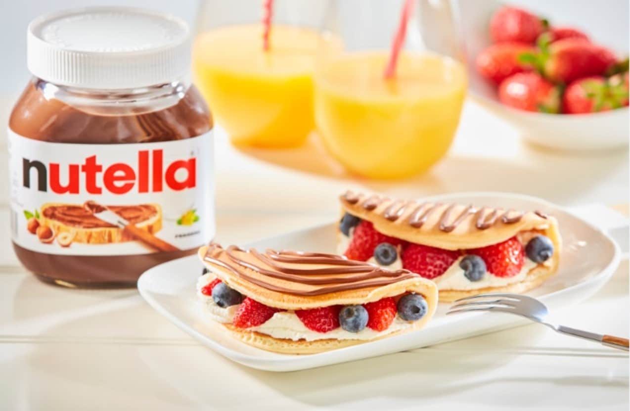 Pancakes with fruit, whipped cream and Nutella drizzle.