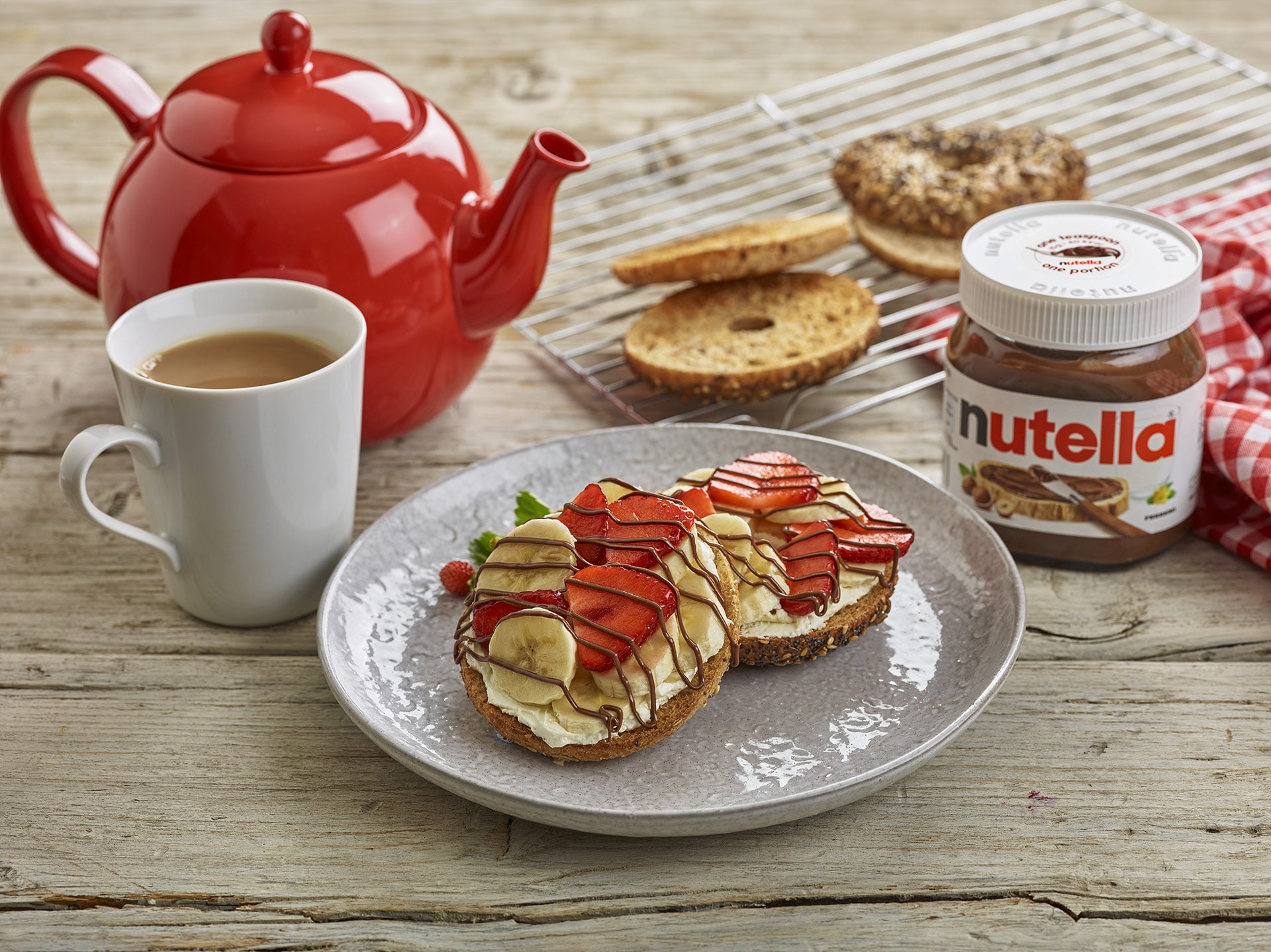 Toasted breakfast bagel spread with Nutella and fresh berries.