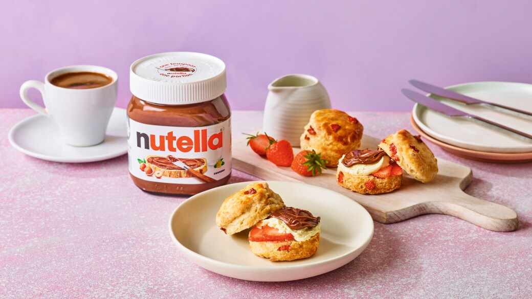 Delicious breakfast scones with strawberries, whipped clotted cream, and Nutella®, served with tea and coffee.