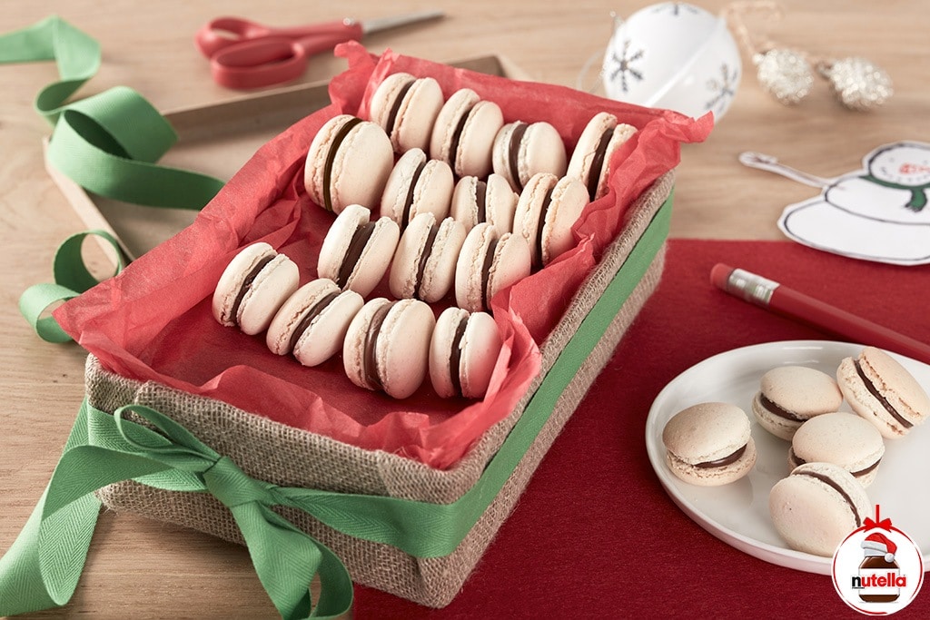 Assorted macarons filled with Nutella ganache, arranged on plate.