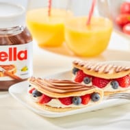 Pancakes with fruit, whipped cream and Nutella drizzle.