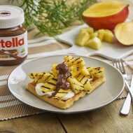 Pineapple and mango waffle topped with Nutella and fresh tropical fruit.