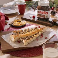 Puff pastry tree filled with Nutella and festive decorations, holiday bake.