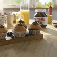 Hazelnut cupcakes topped with Nutella frosting and chopped hazelnuts.