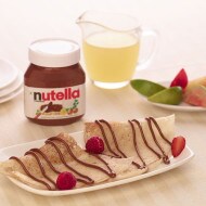 Crispy dosa rolled and filled with Nutella, served with sliced fruit.