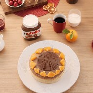 Gluten-free orange sponge cake still life, Nutella serving suggestion on plate.