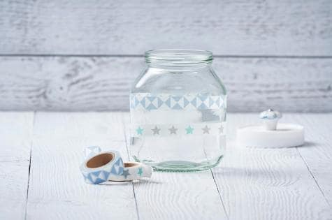 Inserting candle and floral decorations into Nutella jar candle, step three.