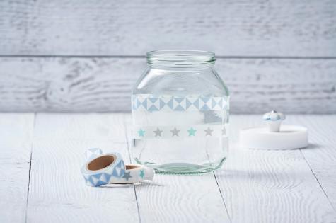 Inserting candle and floral decorations into Nutella jar candle, step three.
