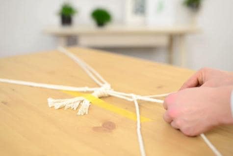 Tutorial step showing Nutella jar hanging from string, craft presentation.