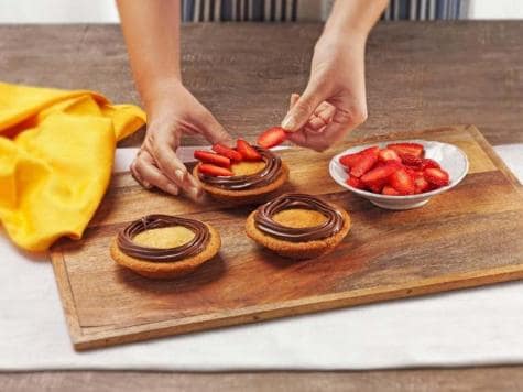 Step three: assembling mini tarts with Nutella and strawberry topping.