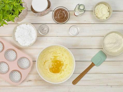 Rolled crepes filled with Nutella and dusted with sugar, styled.