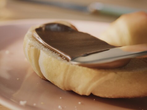 Adding ribbon and labels to Nutella workshop jars, step four.