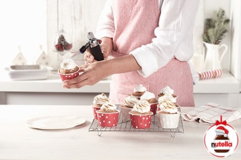 Hazelnut cupcakes topped with Nutella frosting and chopped hazelnuts.