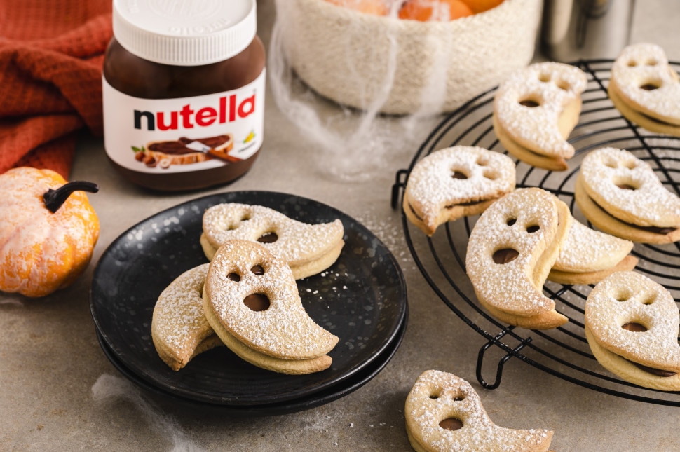 Finished snowmen custard treats with Nutella details and berry garnishes.