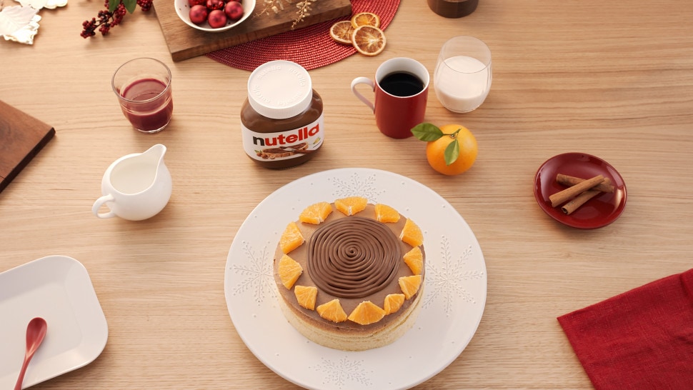 Gluten-free orange sponge cake still life, Nutella serving suggestion on plate.