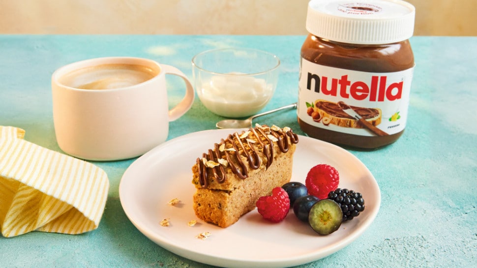 Sliced banana bread loaf with Nutella swirls, rustic serving plate.