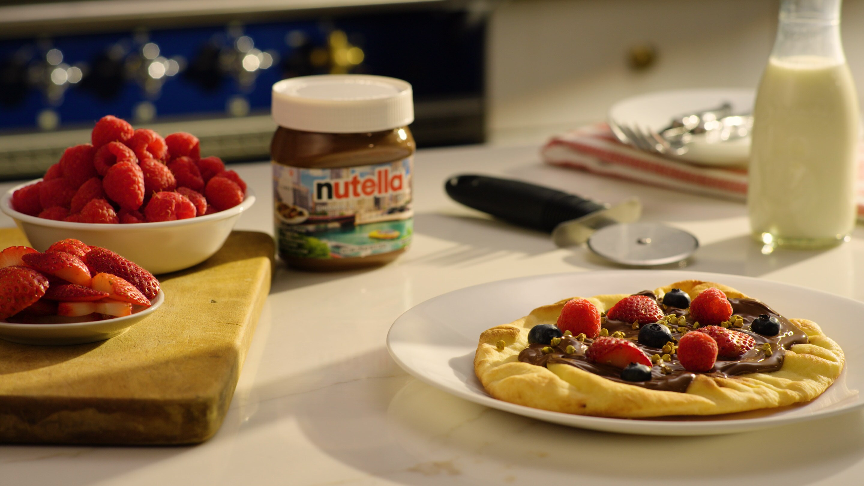 Breakfast pizza topped with Nutella, banana slices and fresh berries