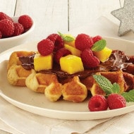 Waffle with Nutella, mango slices, and raspberries.