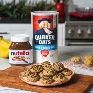 Banana oat cookies drizzled with Nutella on rustic table.