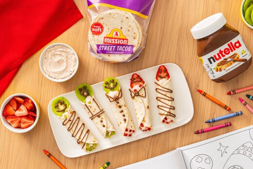 Cheesecake breakfast wrap filled with Nutella and fruit on a bright table.