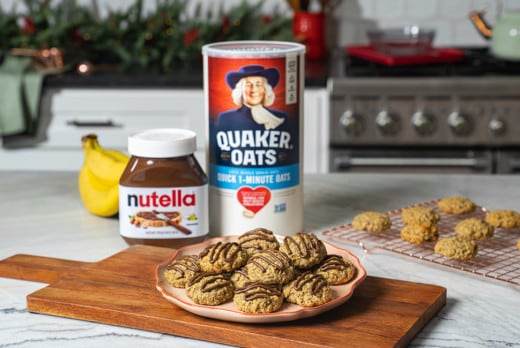 Banana oat cookies drizzled with Nutella on rustic table.