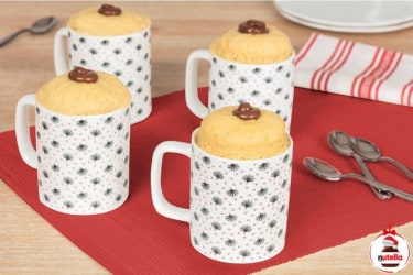 Four mug cakes in are displayed on a red place mat with a dollop of Nutella® in the centre of the cake.